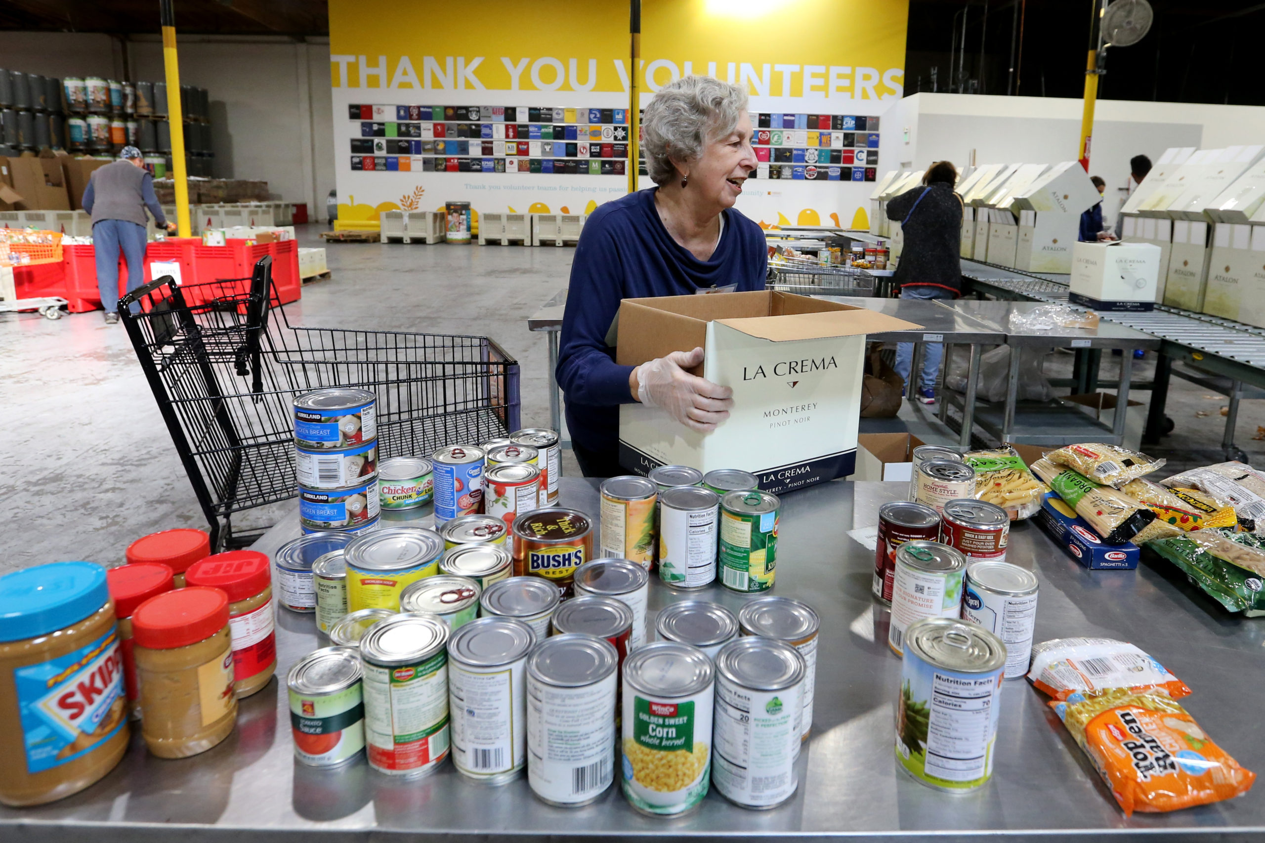 OAKLAND, CALIFORNIA - DECEMBER 13: Joyce Baird, of Berkeley, fills boxes with groceries at Alameda County Food Bank in Oakland, Calif., on Thursday, Dec. 13, 2018. Baird volunteers once a week, she said. (Ray Chavez/Bay Area News Group)